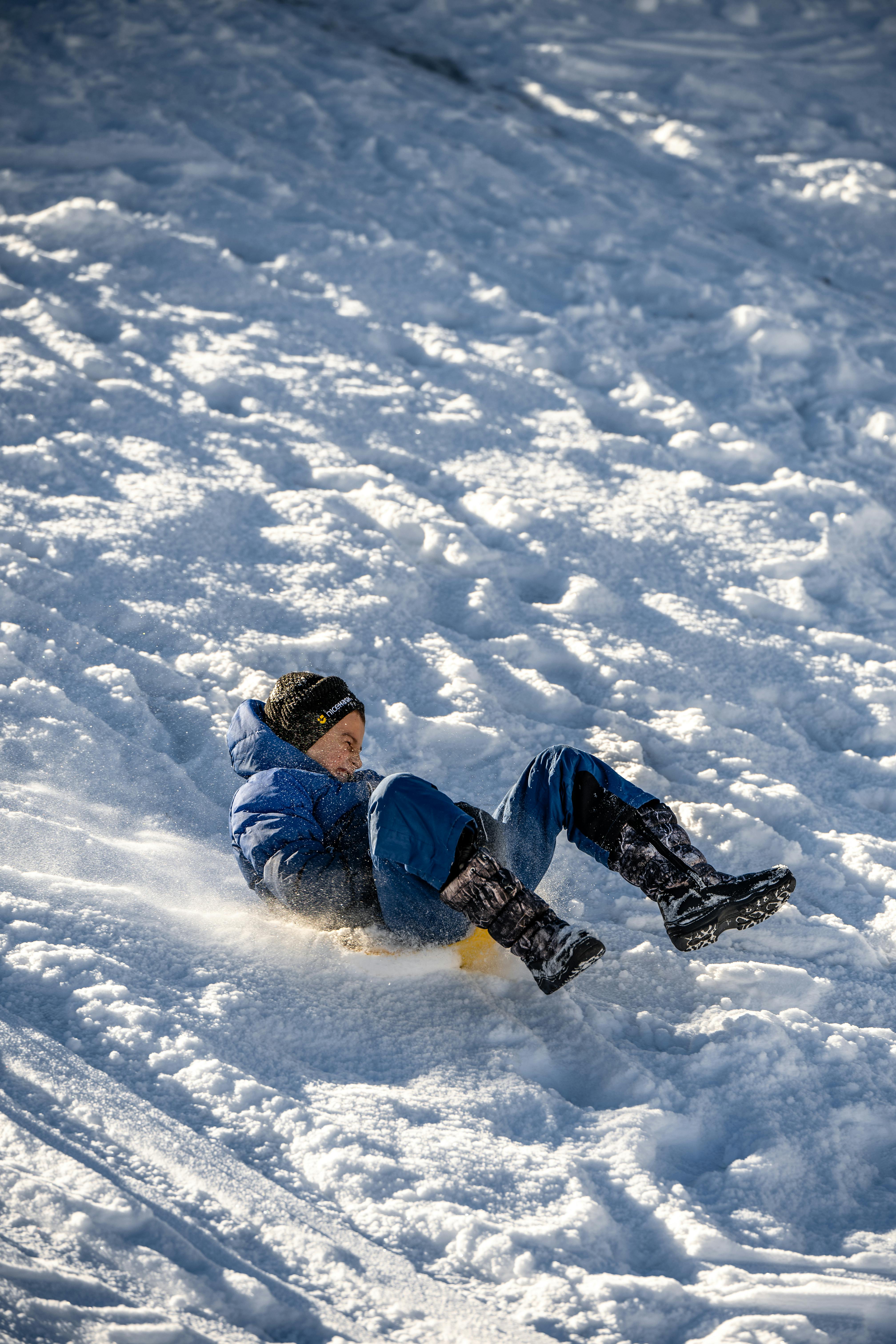 Person sledding down a snowy hill